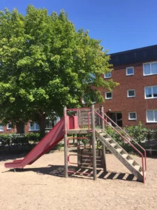 Image of a playground and an apartment building in Tidaholm