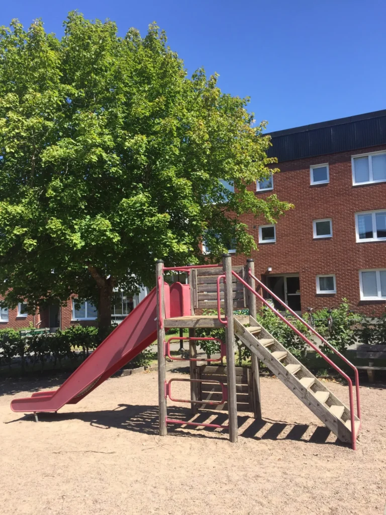 Image of a playground and an apartment building in Tidaholm